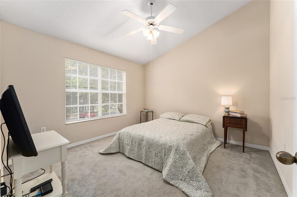 A bedroom with carpeted flooring, a ceiling fan, a window, and a bed — 10000 SW 52ND AVENUE UNIT 42, GAINESVILLE, FL