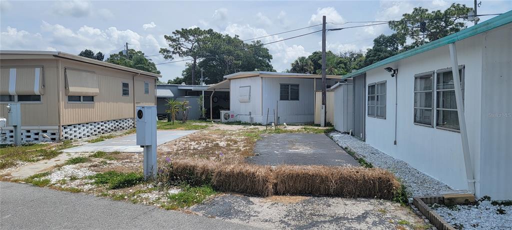An exterior view shows three mobile homes separated by a small, partially paved lot — 4715 67TH STREET N UNIT 25, ST PETERSBURG, FL