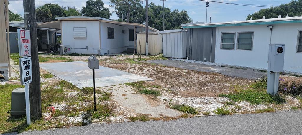 An exterior view shows two mobile homes with a gravel and concrete driveway between them — 4715 67TH STREET N UNIT 25, ST PETERSBURG, FL