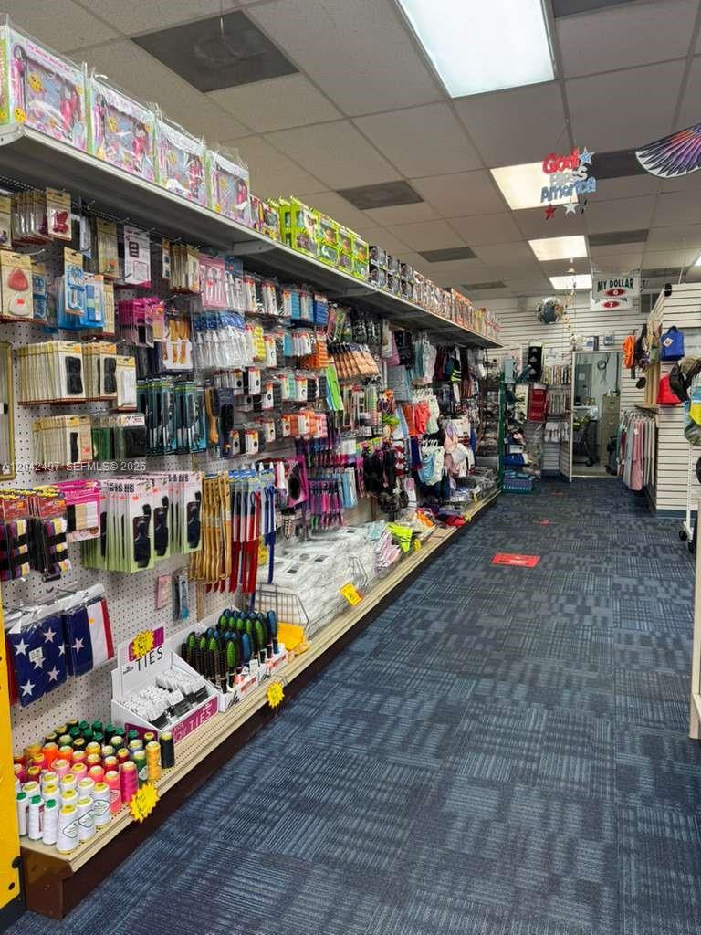 A retail store aisle features shelves stocked with various merchandise and blue patterned carpeting — Convenience Store for Sale, Kendall FL 33175, KENDALL, FL