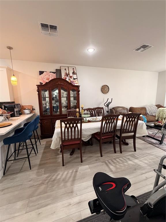 A dining room features a dark wood hutch, a table with six chairs, and blue barstools — 1615 CUMIN DRIVE, POINCIANA, FL