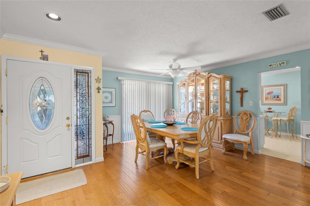 A dining room with hardwood floors, a wooden table, and a matching hutch — 4562 FOREST WOOD TRAIL UNIT 15, SARASOTA, FL