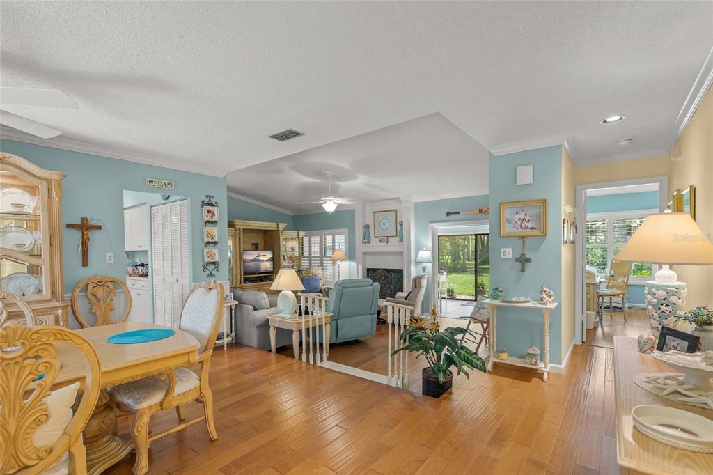 A dining area with hardwood floors opens into a sunken living room with a fireplace — 4562 FOREST WOOD TRAIL UNIT 15, SARASOTA, FL