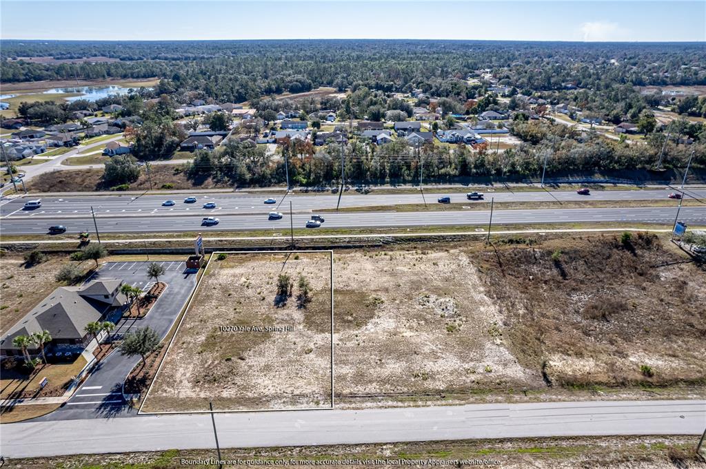An aerial view shows a vacant rectangular lot next to a paved parking area — 10270 YALE AVENUE, WEEKI WACHEE, FL