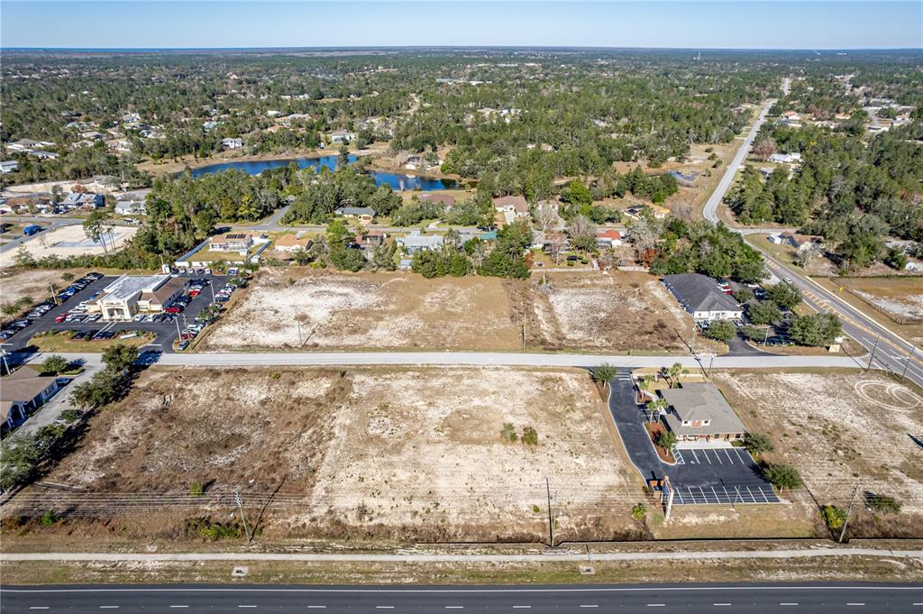 An aerial view shows several vacant lots situated between a highway and a residential area — 10270 YALE AVENUE, WEEKI WACHEE, FL