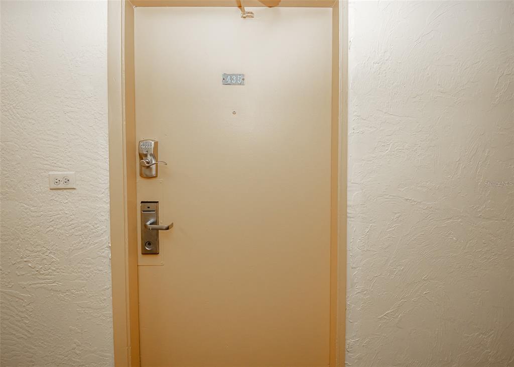 A beige door with a keypad lock and the number 435 is set in a wall — 2301 S ATLANTIC AVENUE UNIT 435, DAYTONA BEACH, FL