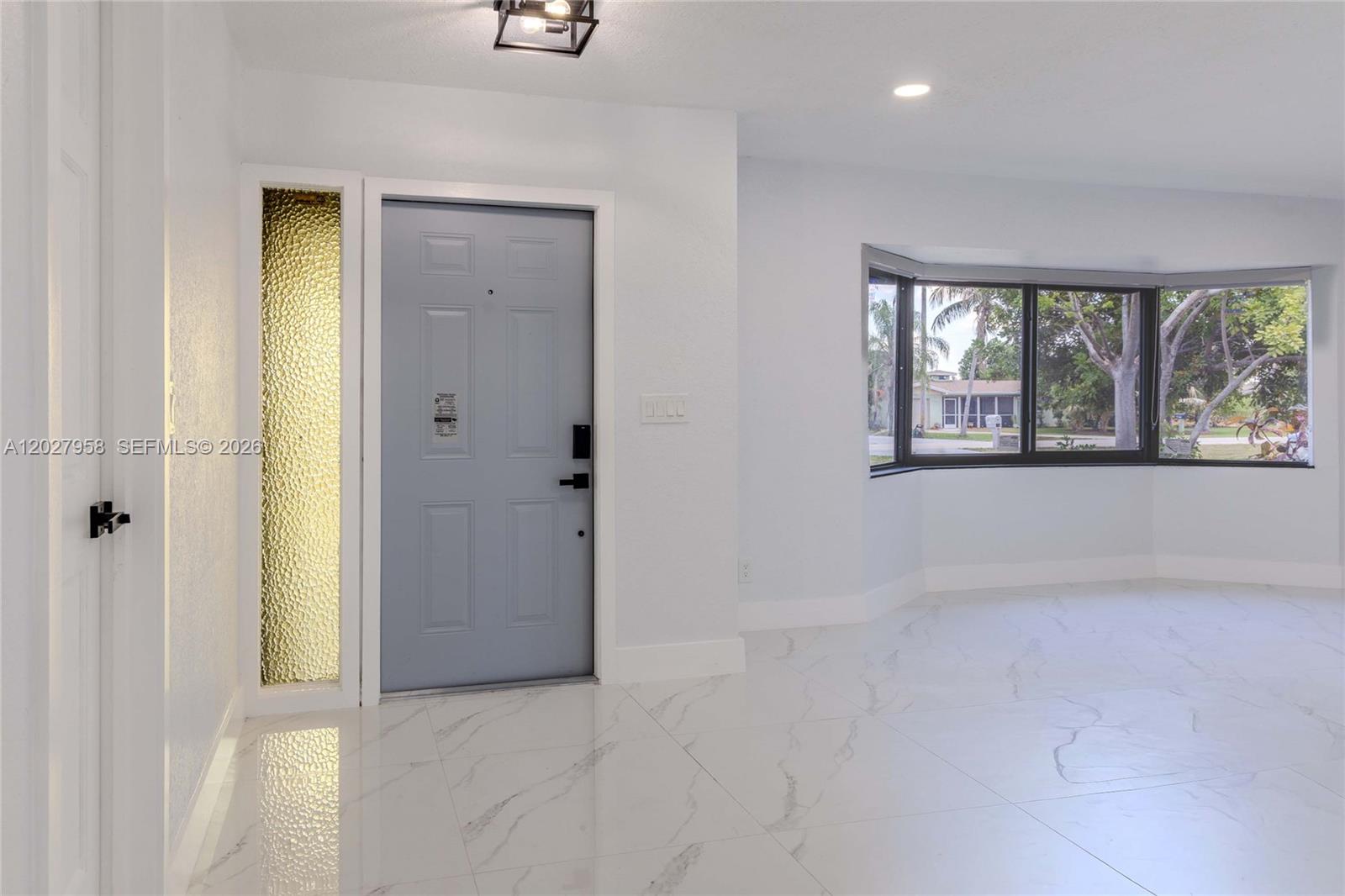 An entryway features a light blue door, textured glass sidelight, and white marble-look tile flooring — 1648 Coral Point Dr, Cape Coral FL 33990, CAPE CORAL, FL