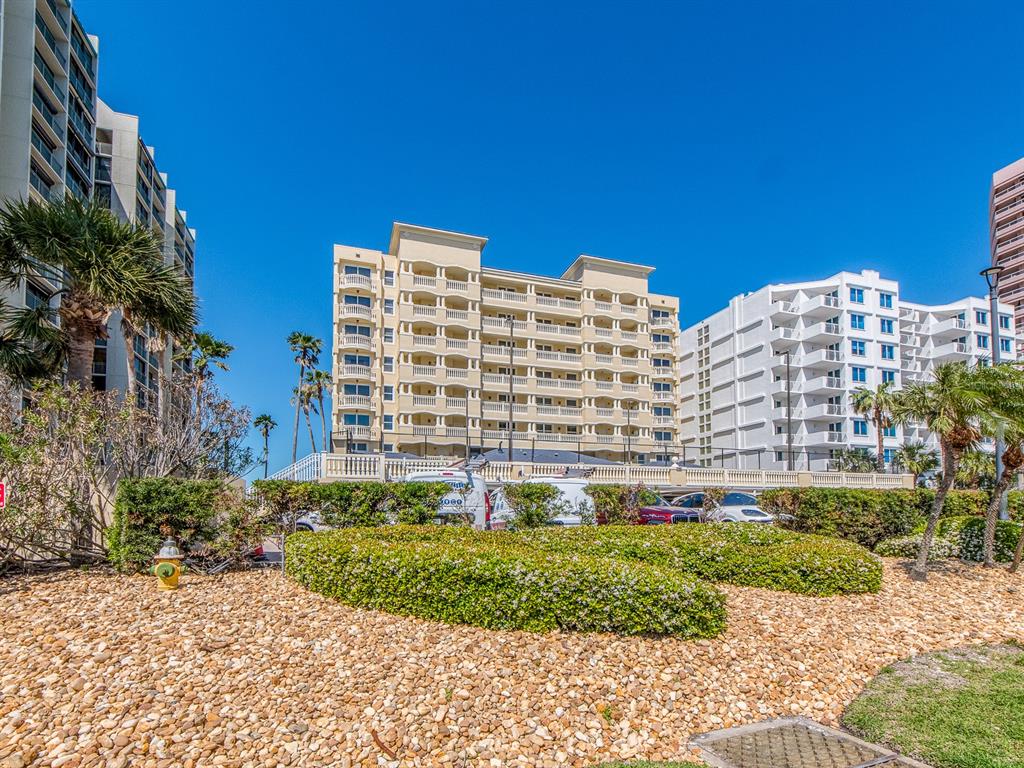 A view of several multi-story hotel buildings behind a landscaped garden and gravel area — 1370 GULF BOULEVARD UNIT 204, CLEARWATER, FL