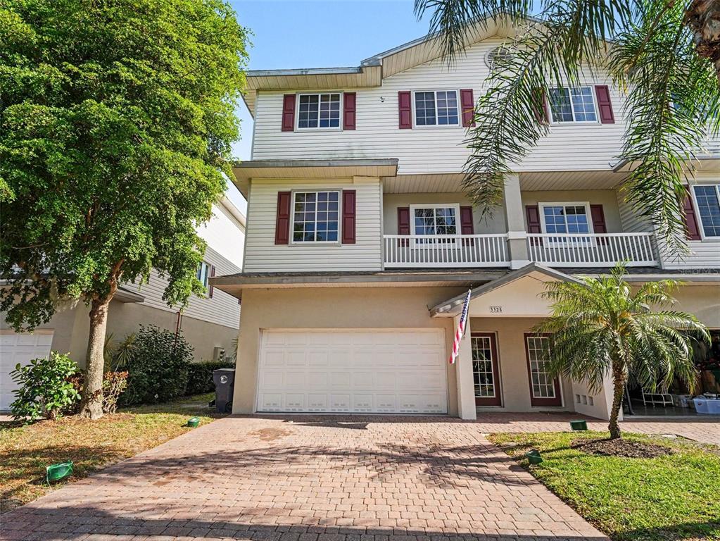 A three-story townhouse with a paved driveway, a two-car garage, and a small balcony — 3325 10TH LANE W, PALMETTO, FL