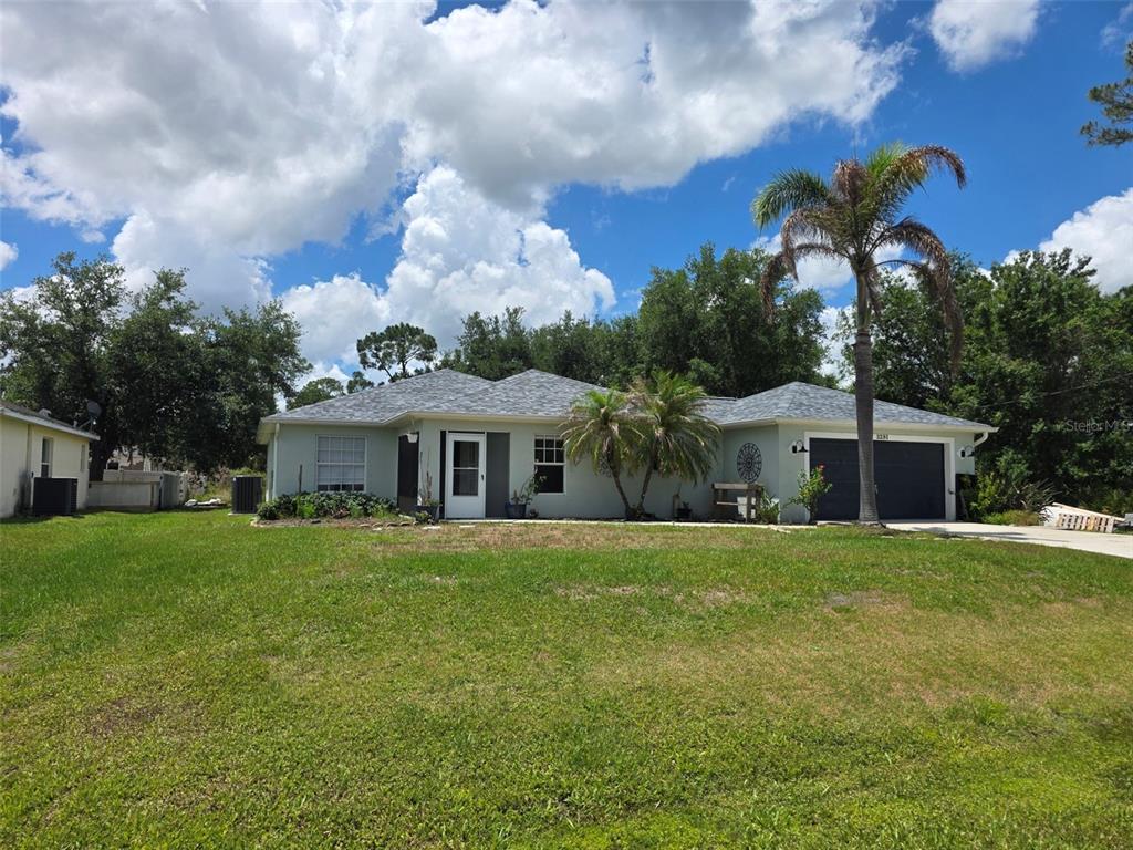 A single-story house with a gray roof, light-colored siding, and a palm tree in front — 3291 HORACE AVENUE, NORTH PORT, FL