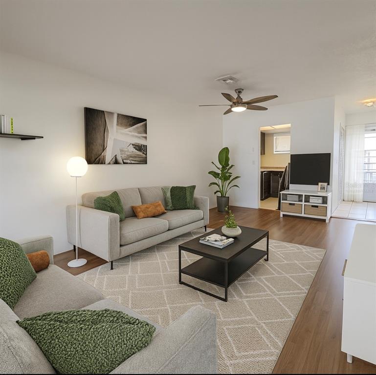 A living room features light-colored sofas, a coffee table, a rug, and wood-look flooring — 1014 E SOUTH STREET UNIT 16, ORLANDO, FL