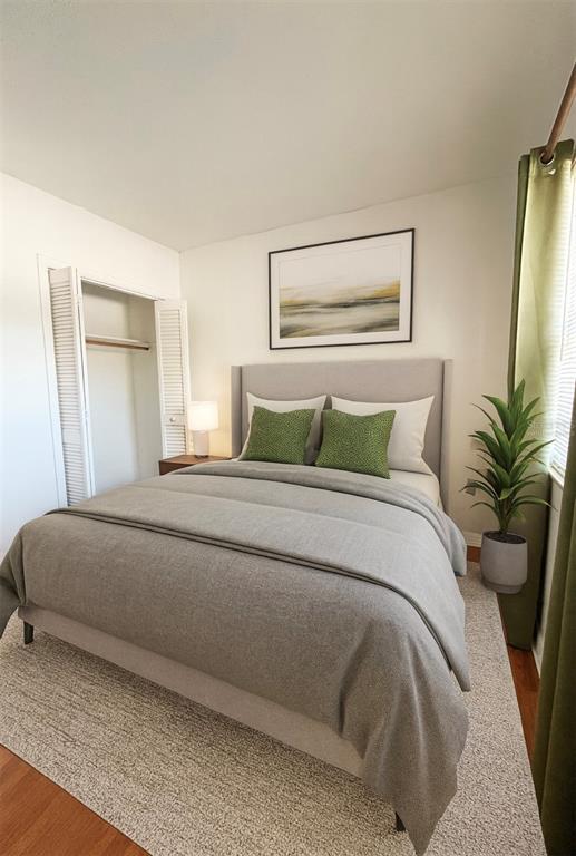 This bedroom features a gray upholstered bed, green accent pillows, and a white closet — 1014 E SOUTH STREET UNIT 16, ORLANDO, FL