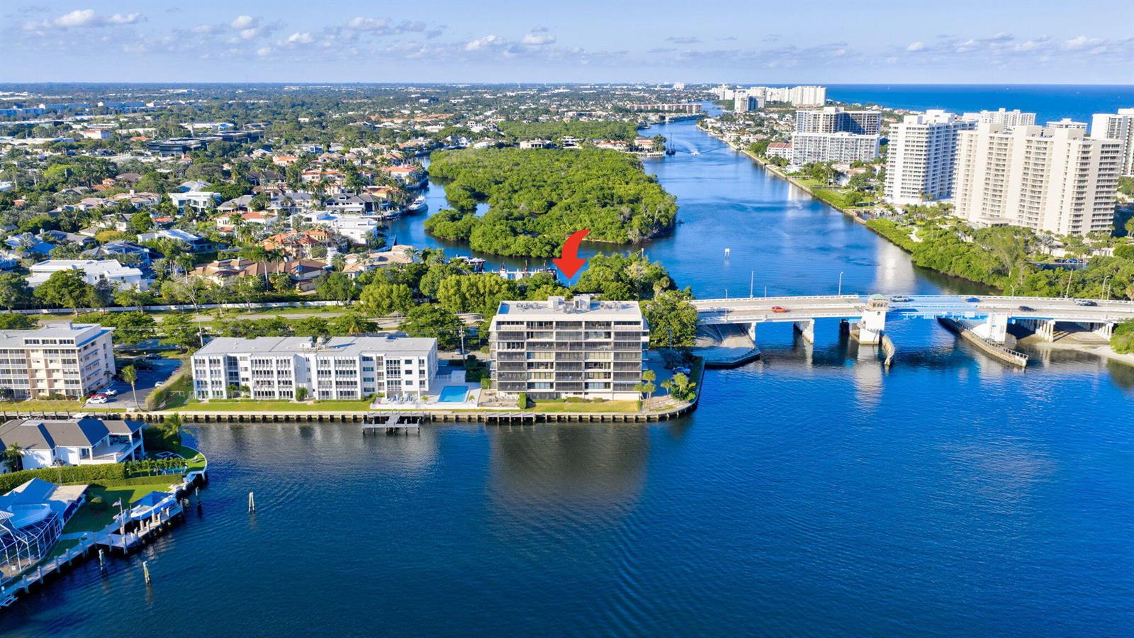 An aerial view of a waterfront condominium building next to a bridge and canal — 900 NE Spanish River Boulevard # 2w, Boca Raton FL 33431, BOCA RATON, FL