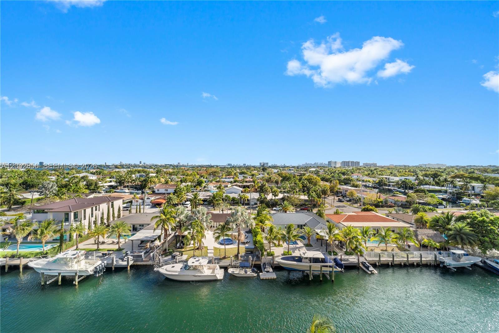 An aerial view shows several waterfront houses with private docks and boats on a canal — 2350 NE 135th St # 808, North Miami FL 33181, NORTH MIAMI, FL