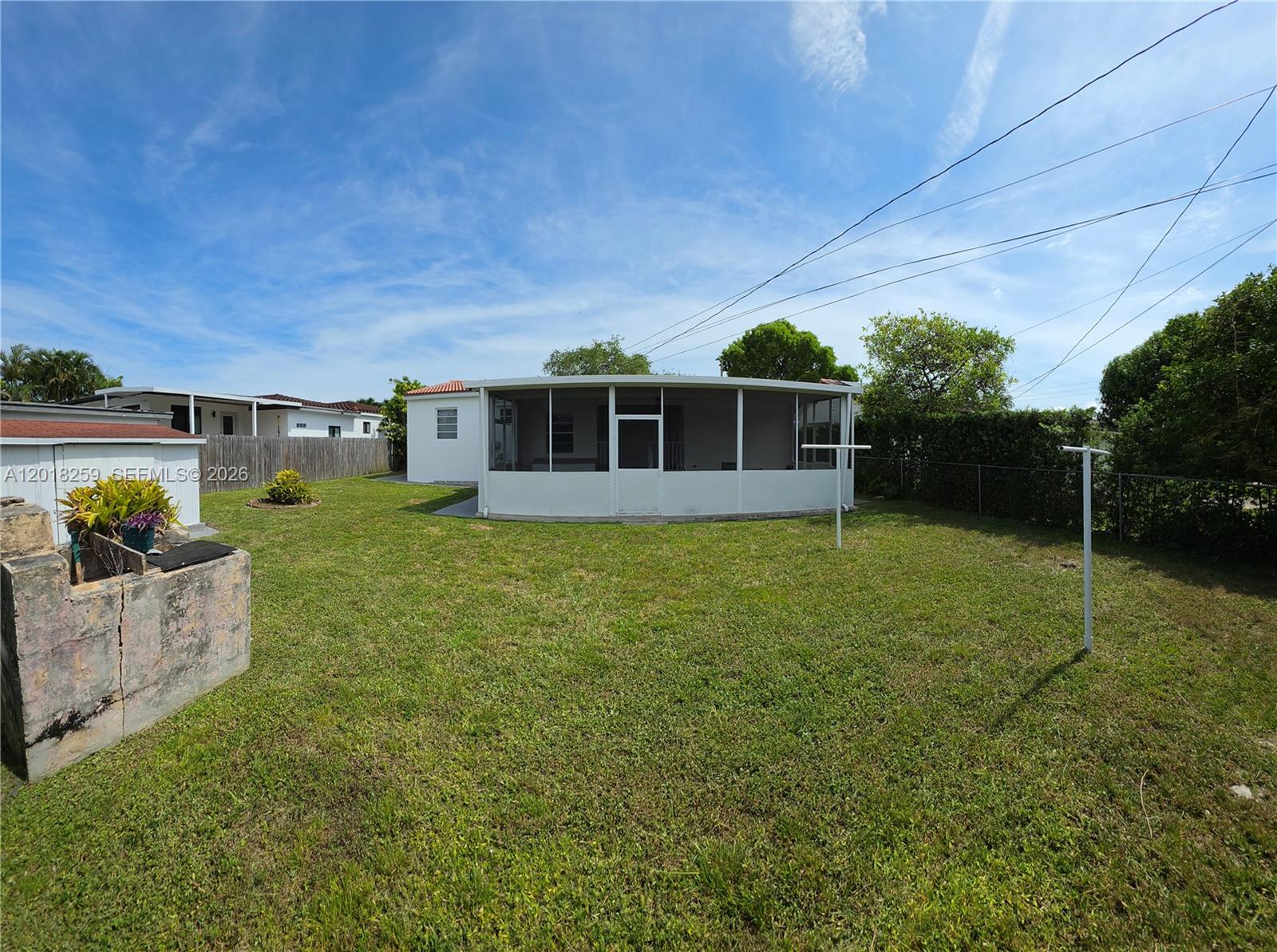 A backyard features a white screened-in patio, a grassy lawn, and a concrete structure — 4601 SW 5th St # 0, Miami FL 33134, MIAMI, FL