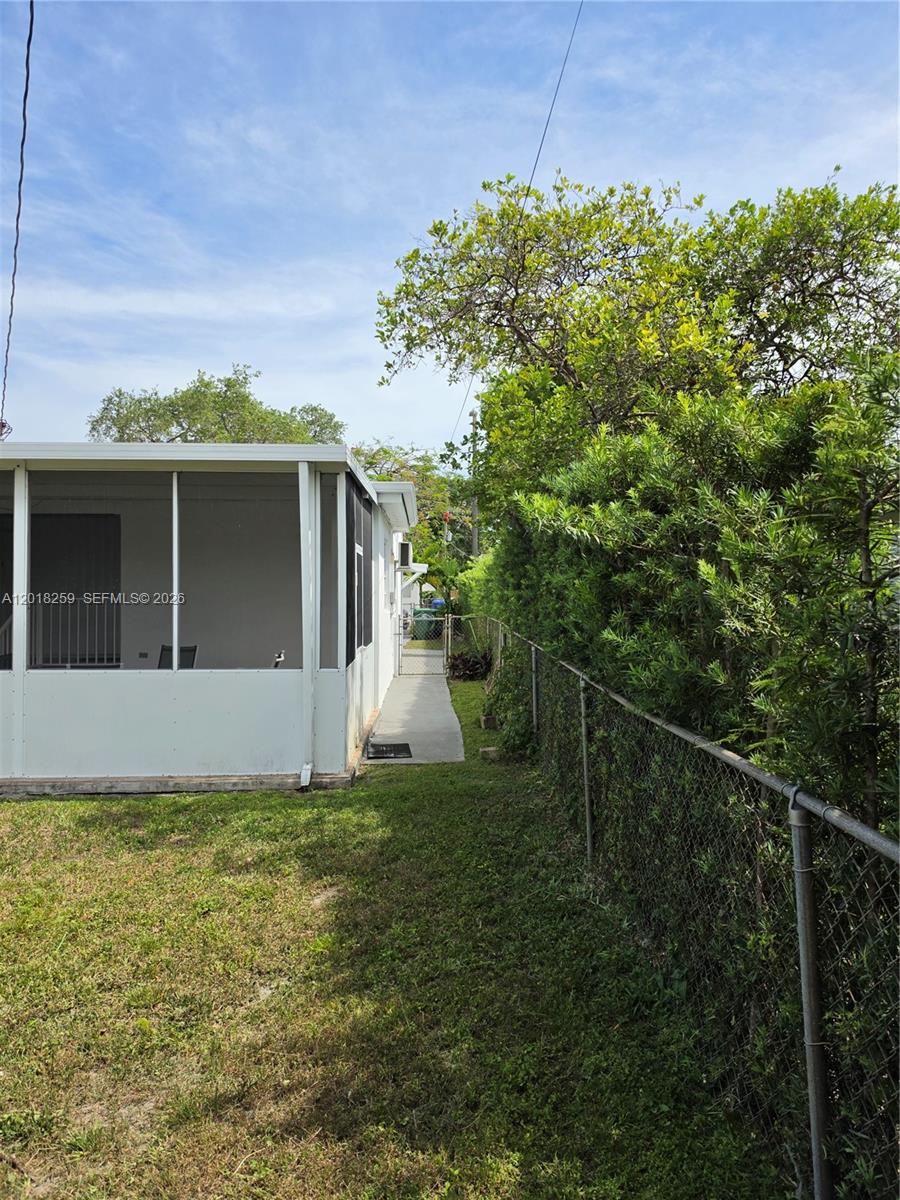 A view of a side yard with a screened-in porch and a chain-link fence — 4601 SW 5th St # 0, Miami FL 33134, MIAMI, FL