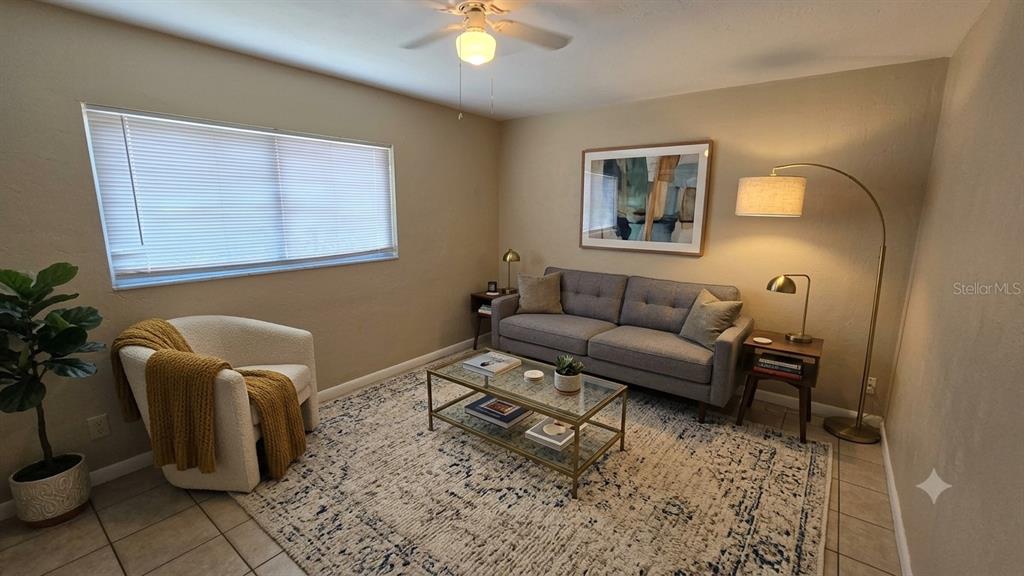 A living room features a gray sofa, a white armchair, and a glass coffee table — 716 21ST STREET N, ST PETERSBURG, FL