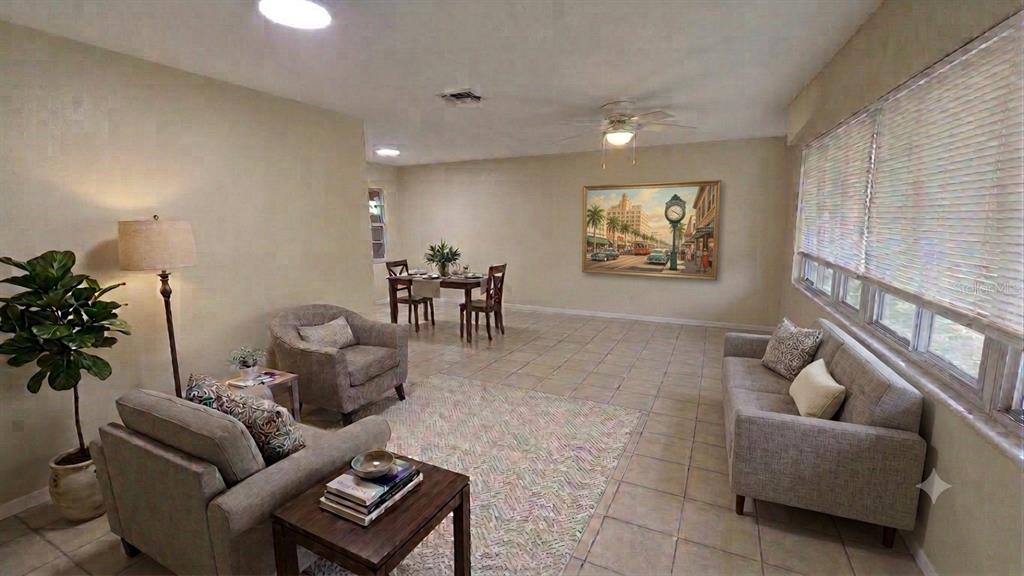 A living and dining room with tile floors, a ceiling fan, and large windows — 716 21ST STREET N, ST PETERSBURG, FL