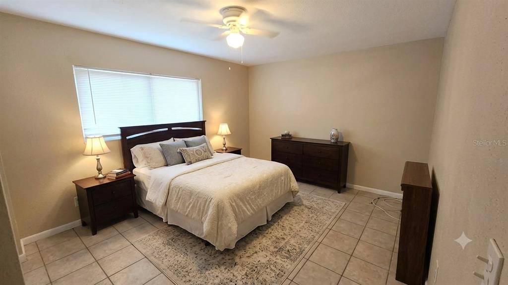 A bedroom features a bed, two nightstands, a dresser, and tile flooring — 716 21ST STREET N, ST PETERSBURG, FL