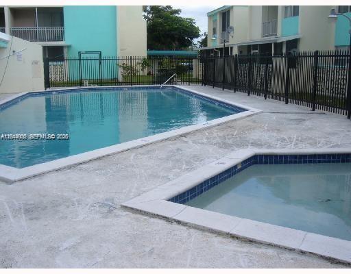 A swimming pool and a smaller hot tub are located on a concrete pool deck — 2017 NW 46th Ave # A406, Lauderhill FL 33313, LAUDERHILL, FL