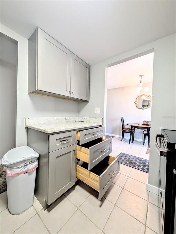 A kitchen area features gray cabinets, a granite countertop, and open drawers — 2008 CANAL DRIVE UNIT M3, BRADENTON, FL