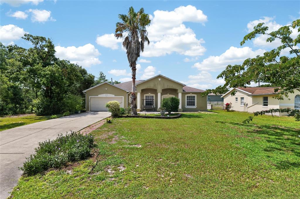 A single-story house with a palm tree, a concrete driveway, and a grassy front yard — 2728 SW 153RD PLACE ROAD, OCALA, FL