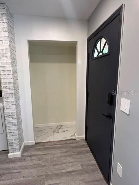 An interior view shows a dark front door next to a small closet with tiled flooring — 3204 BRIGADOON DRIVE, CLEARWATER, FL