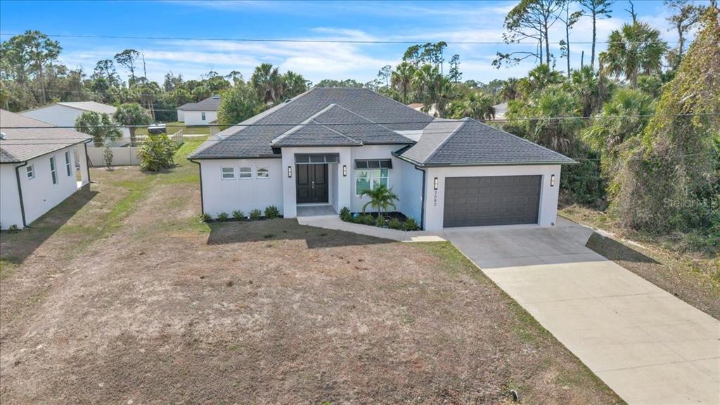 A single-story house with a gray roof, white exterior, and an attached two-car garage — 3083 JEANNIN DRIVE, NORTH PORT, FL