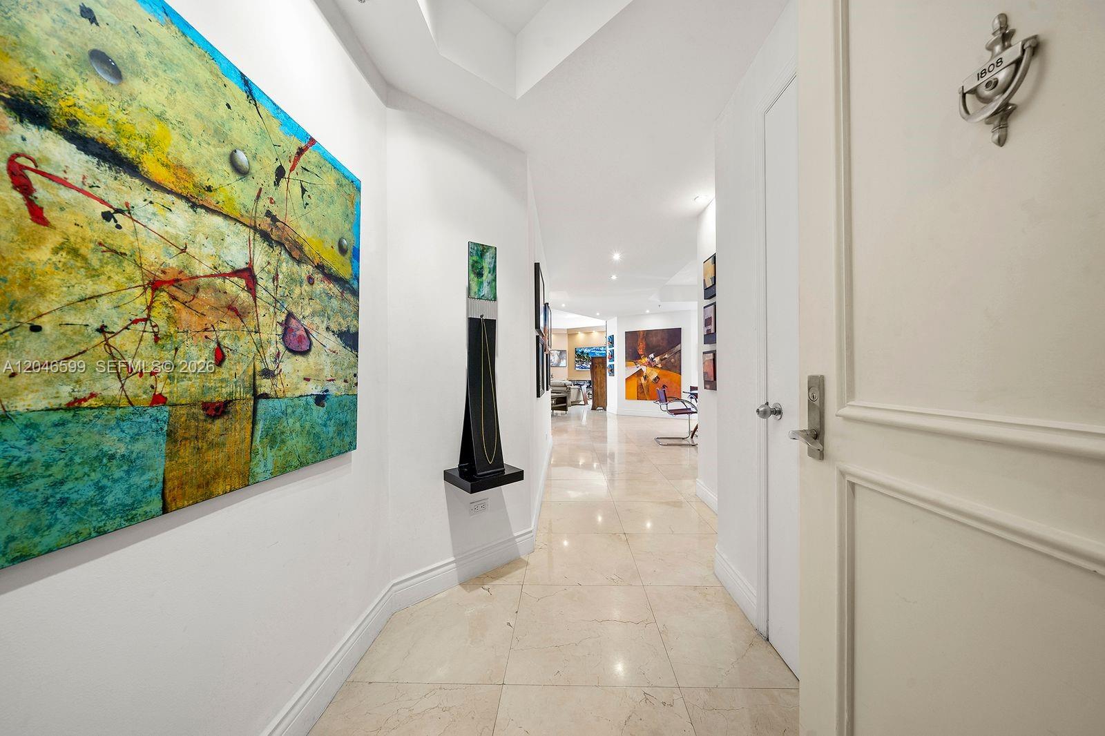 A hallway with marble floors leads to a living area featuring abstract wall art — 808 Brickell Key Dr # 1808, Miami FL 33131, MIAMI, FL