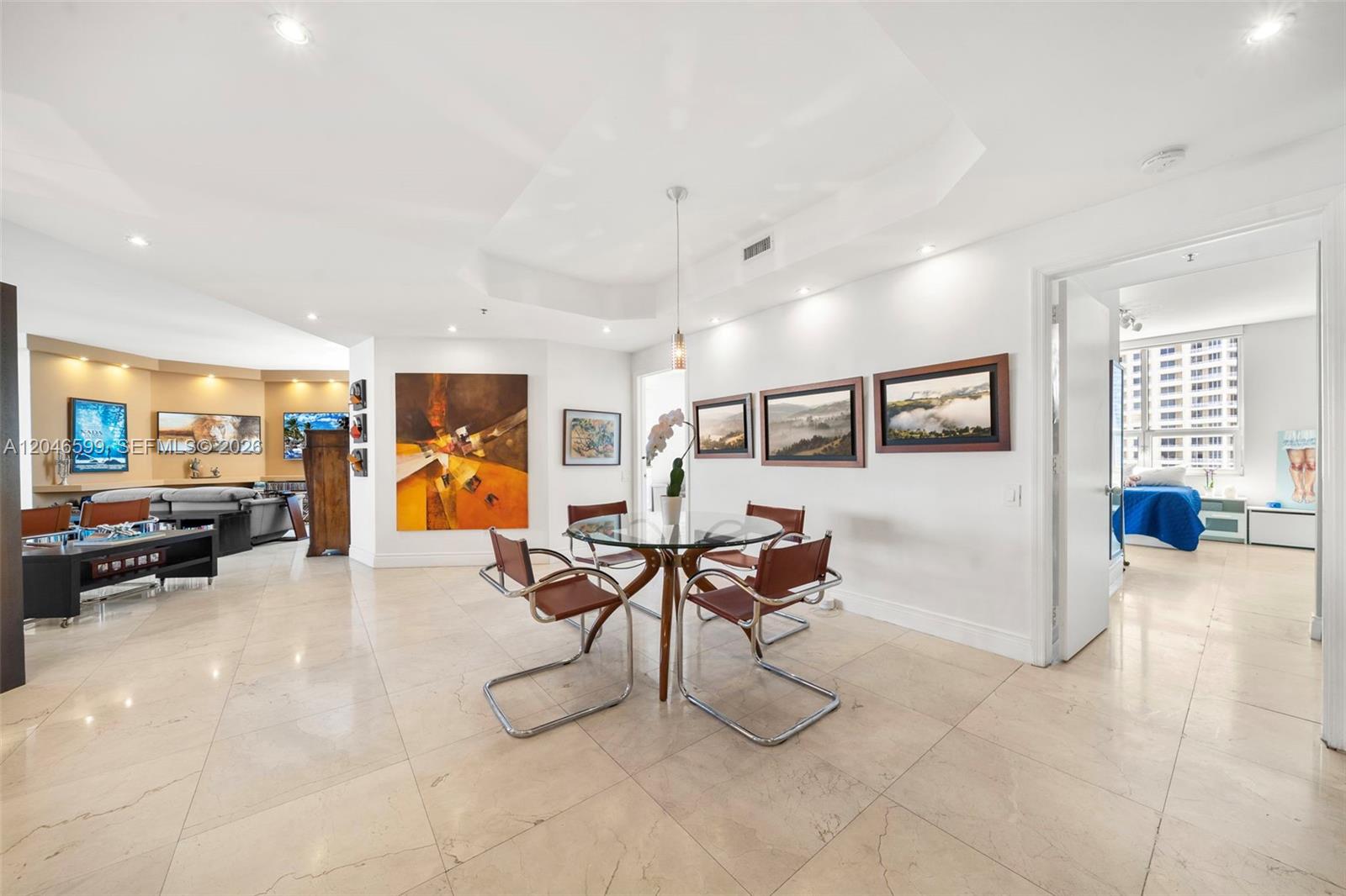 A dining area with a glass table and four chairs sits in an open-plan living space — 808 Brickell Key Dr # 1808, Miami FL 33131, MIAMI, FL