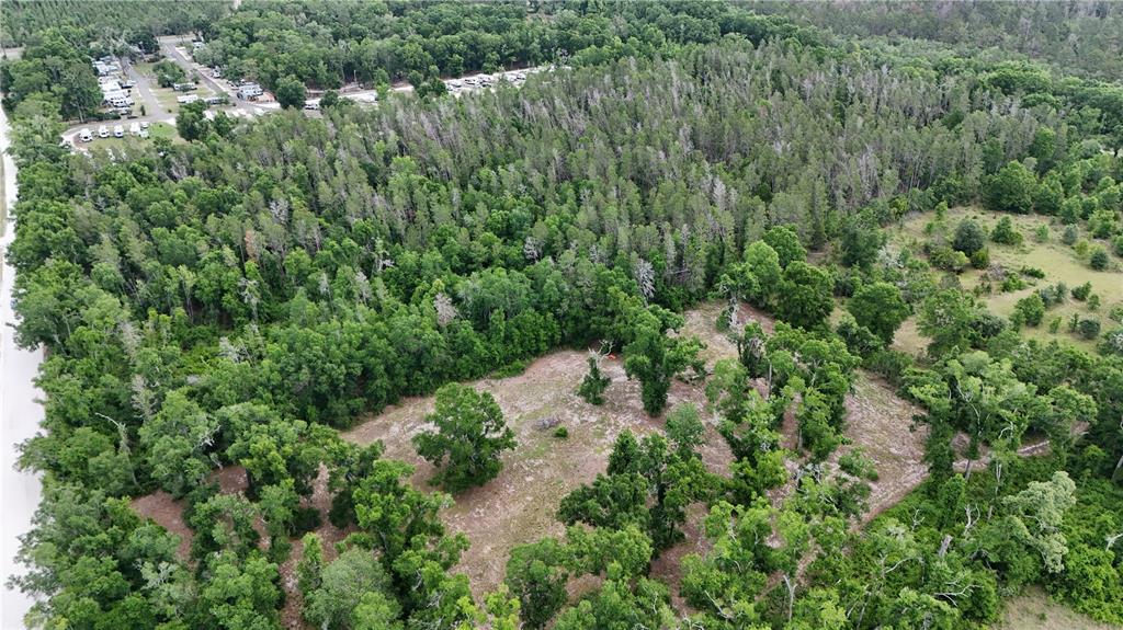 An aerial view shows a partially cleared, wooded lot adjacent to a paved road — 0 SUNTILT COURT, WHITE SPRINGS, FL