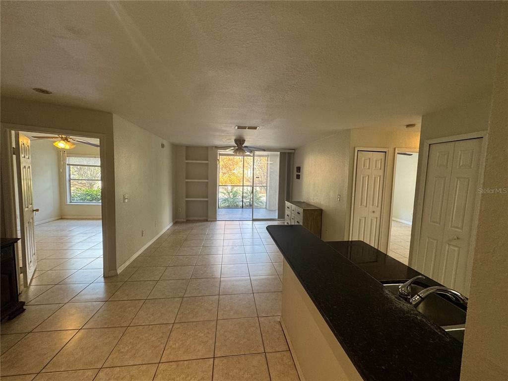 A view from a kitchen counter looking toward a living area with tile flooring — 7605 PISSARRO DRIVE UNIT 13108, ORLANDO, FL