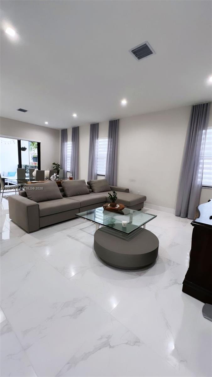 A living room features a grey sectional sofa, a glass-topped coffee table, and white tile floors — 8253 NW 47th Ln, Doral FL 33166, DORAL, FL