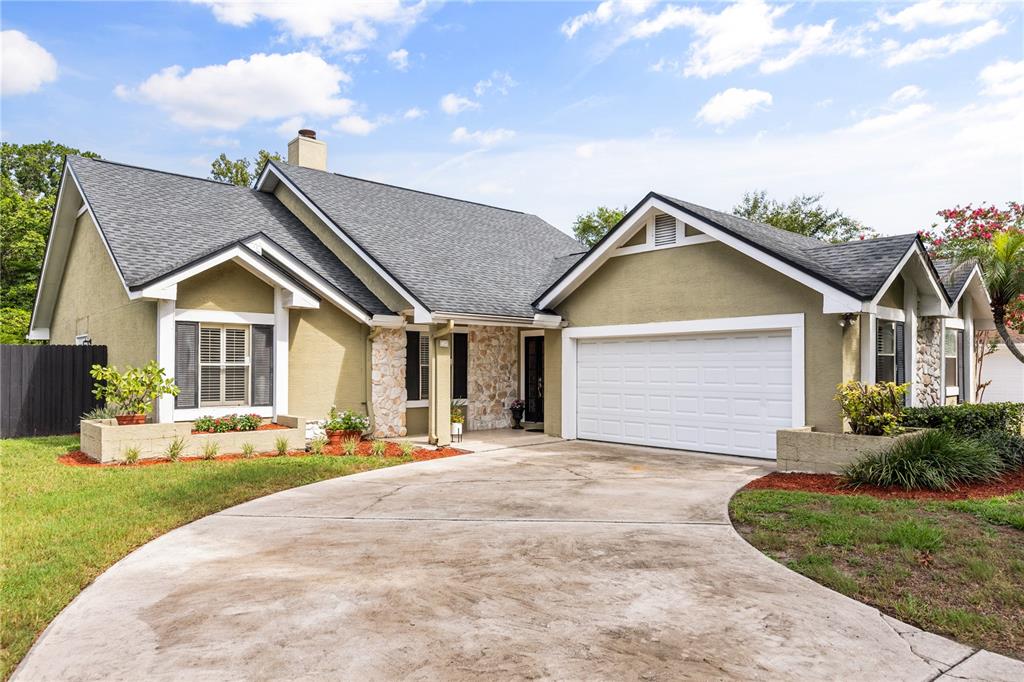A single-story house with a stone facade, olive-green stucco, and a two-car garage — 3200 HEATHGATE COURT, ORLANDO, FL