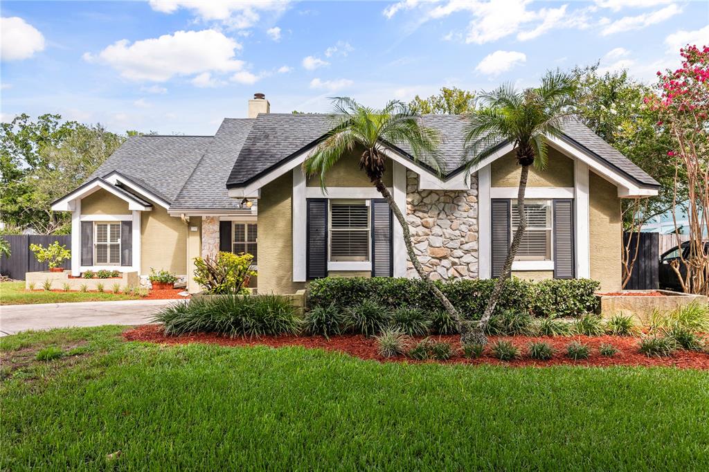 A single-story house with a stone facade, two palm trees, and a green lawn — 3200 HEATHGATE COURT, ORLANDO, FL