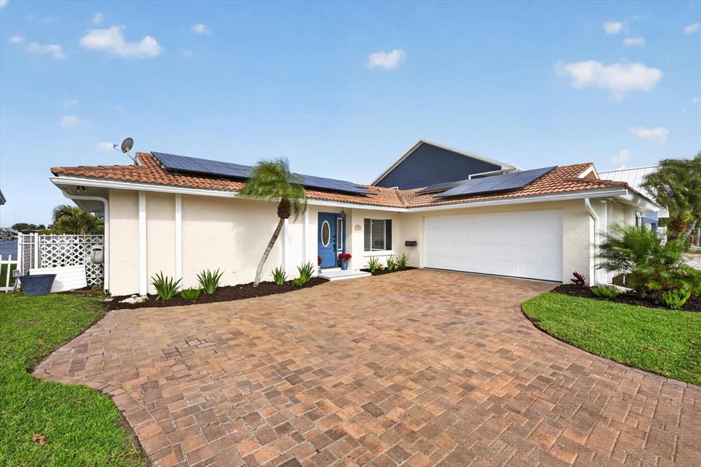 A single-story house with a tiled roof, solar panels, and a paved driveway — 4969 MARLIN DRIVE, NEW PORT RICHEY, FL