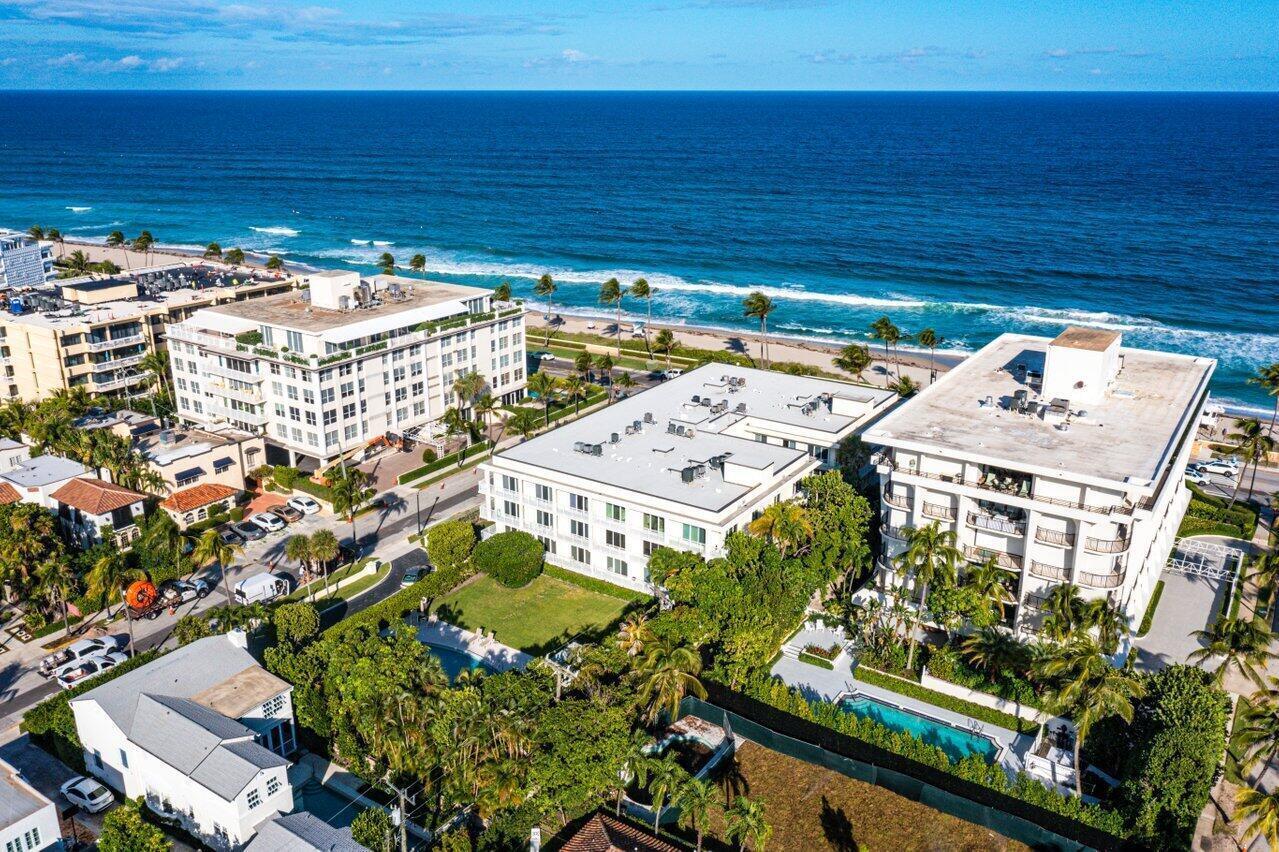 An aerial view of coastal apartment buildings, lush landscaping, and a swimming pool near the ocean — 350 S Ocean Boulevard # 201, Palm Beach FL 33480, PALM BEACH, FL