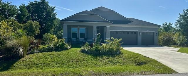 A single-story house with a gray exterior, a three-car garage, and a landscaped front yard — 15079 WICHITA ROAD, PORT CHARLOTTE, FL
