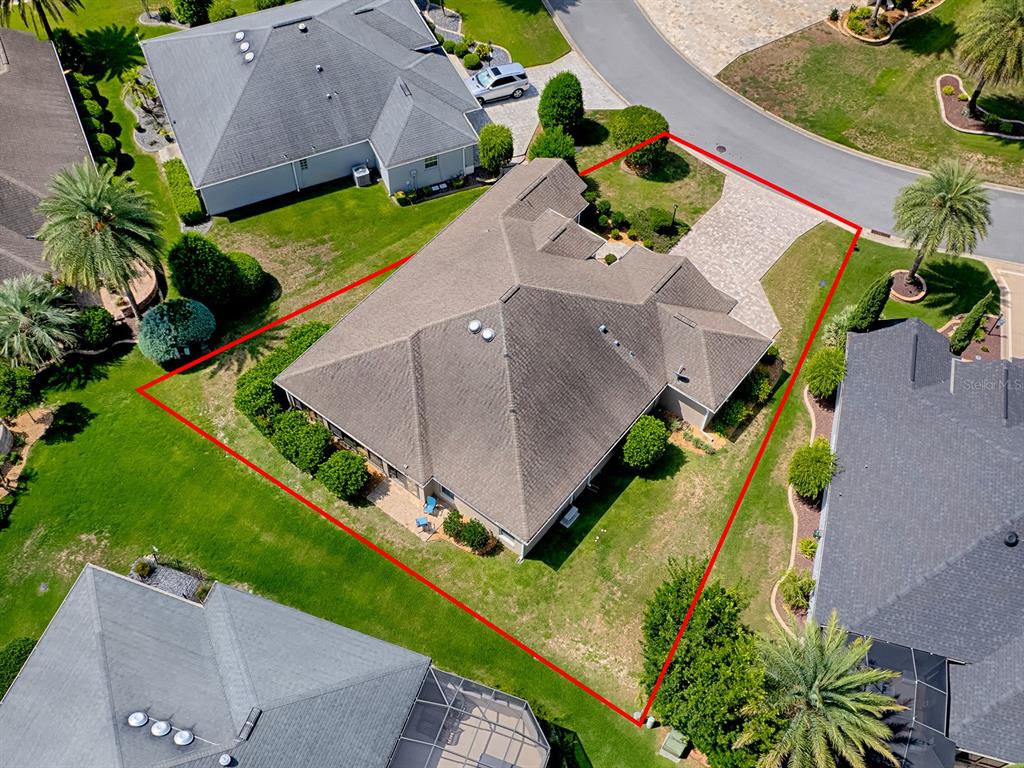An aerial view shows a single-story house with a shingled roof and paved driveway — 2935 LURAVILLE ROAD, THE VILLAGES, FL