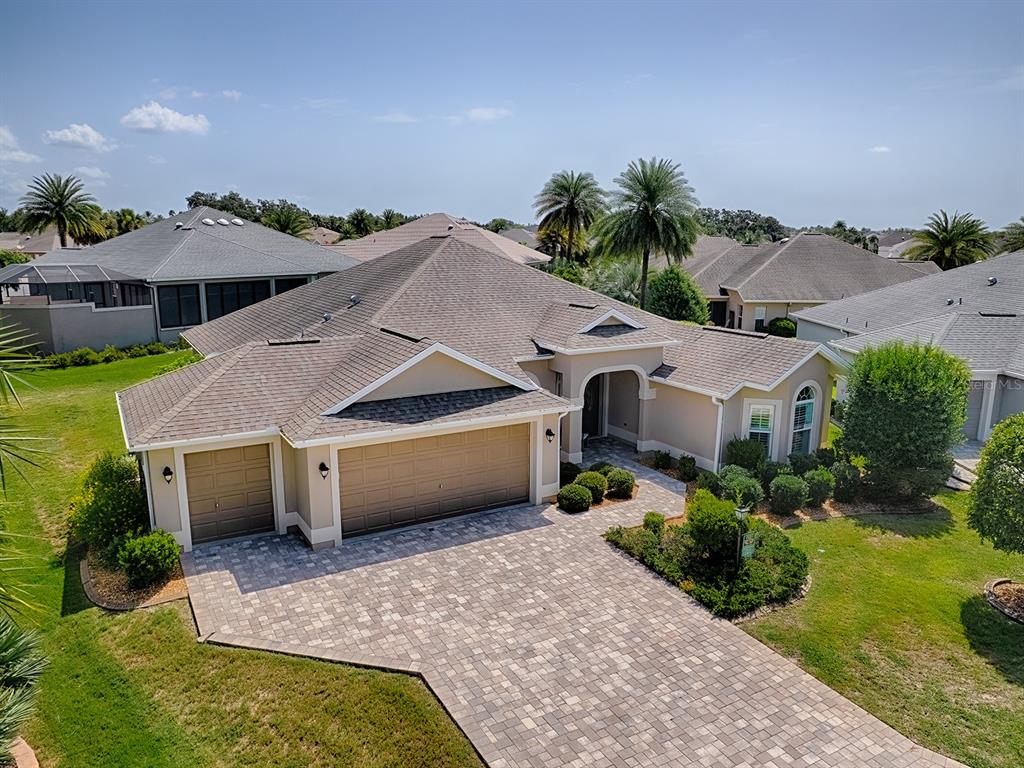 An aerial view of a tan single-story house with a paved driveway and shingled roof — 2935 LURAVILLE ROAD, THE VILLAGES, FL