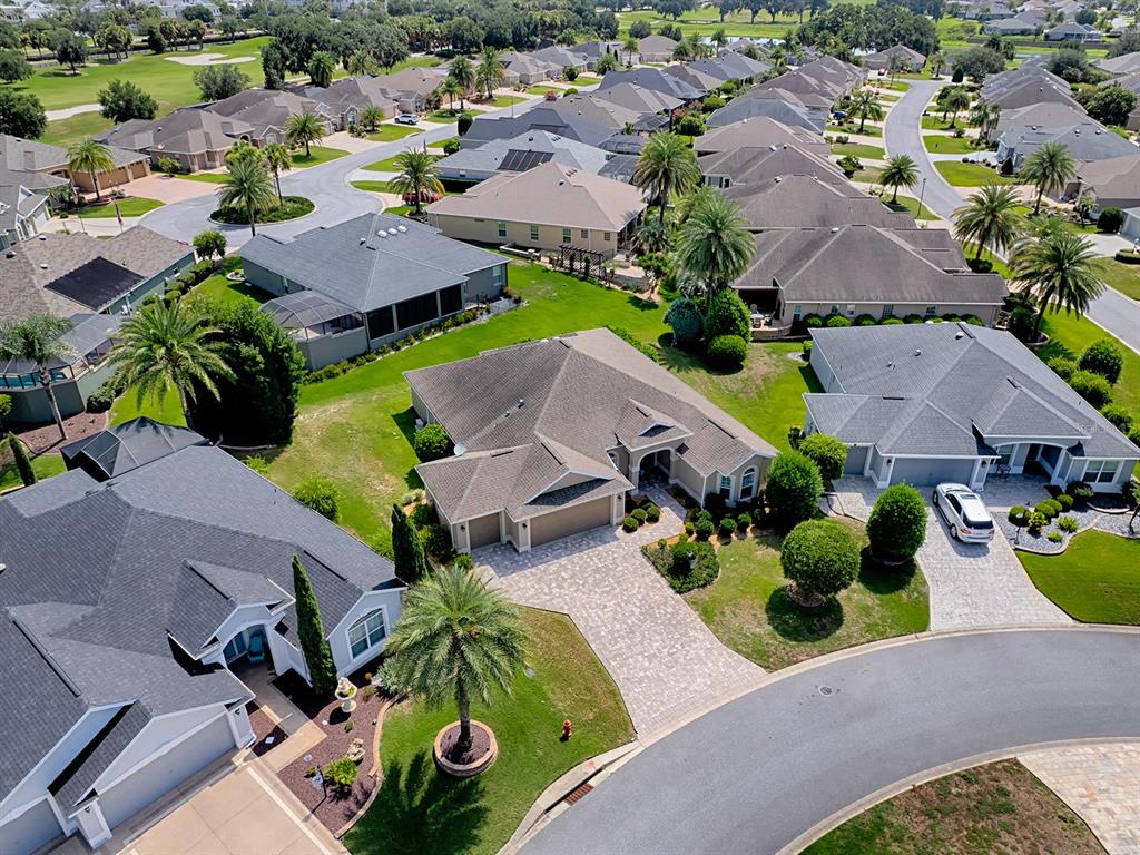 An aerial view shows several suburban houses with paved driveways and palm trees — 2935 LURAVILLE ROAD, THE VILLAGES, FL