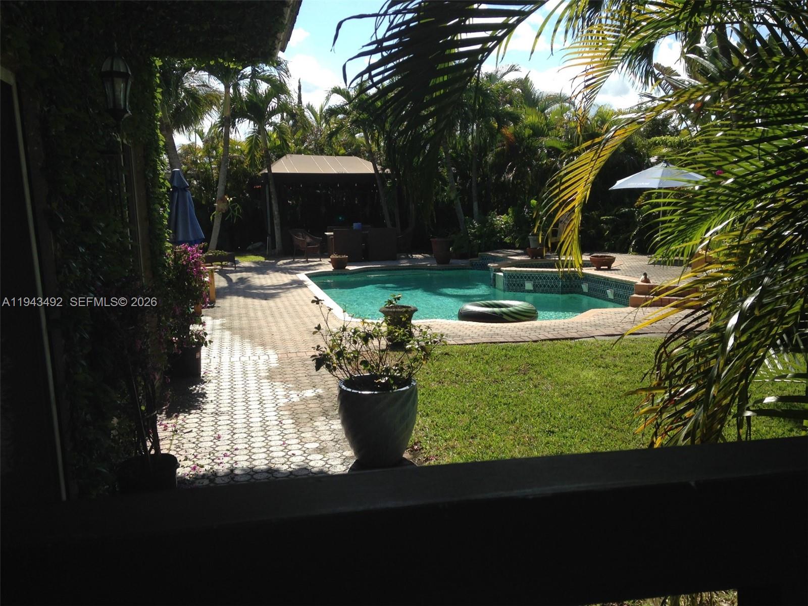 A backyard features a swimming pool, a paved patio, a gazebo, and lush tropical landscaping — 15448 SW 92nd St, Miami FL 33196, MIAMI, FL