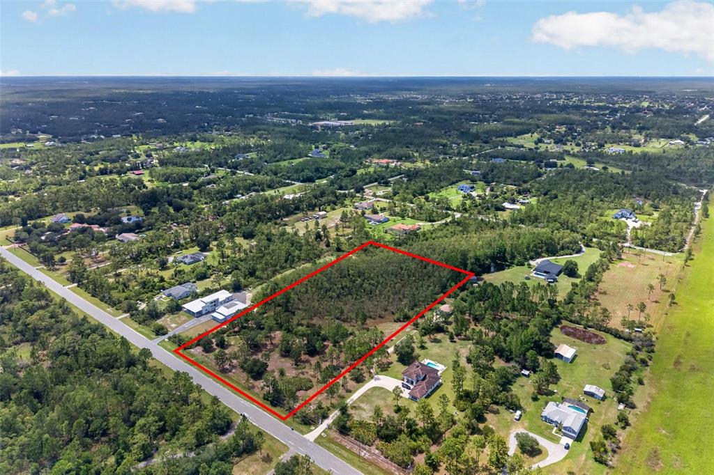 An aerial view shows a rectangular plot of land outlined in red near a road — 20829 QUARTERLY PARKWAY, ORLANDO, FL