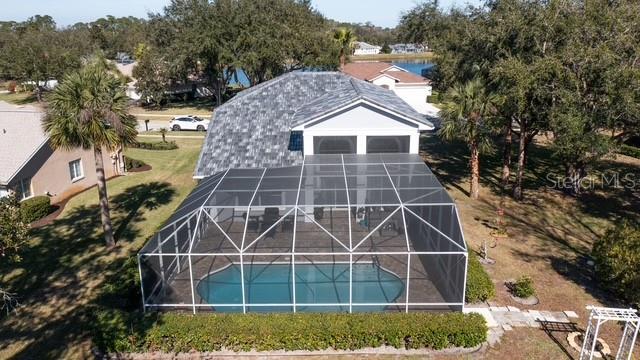 An aerial view shows a house with a screened-in pool and a gray shingled roof — 9 MOUNT VERNON LANE, PALM COAST, FL