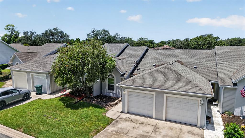 An aerial view shows two attached houses with gray roofs, white garage doors, and a lawn — 2501 SE 18TH CIRCLE, OCALA, FL