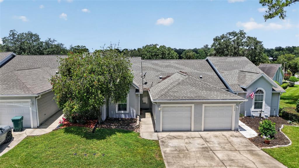 An exterior view of a single-story duplex with two garages and a large tree — 2501 SE 18TH CIRCLE, OCALA, FL