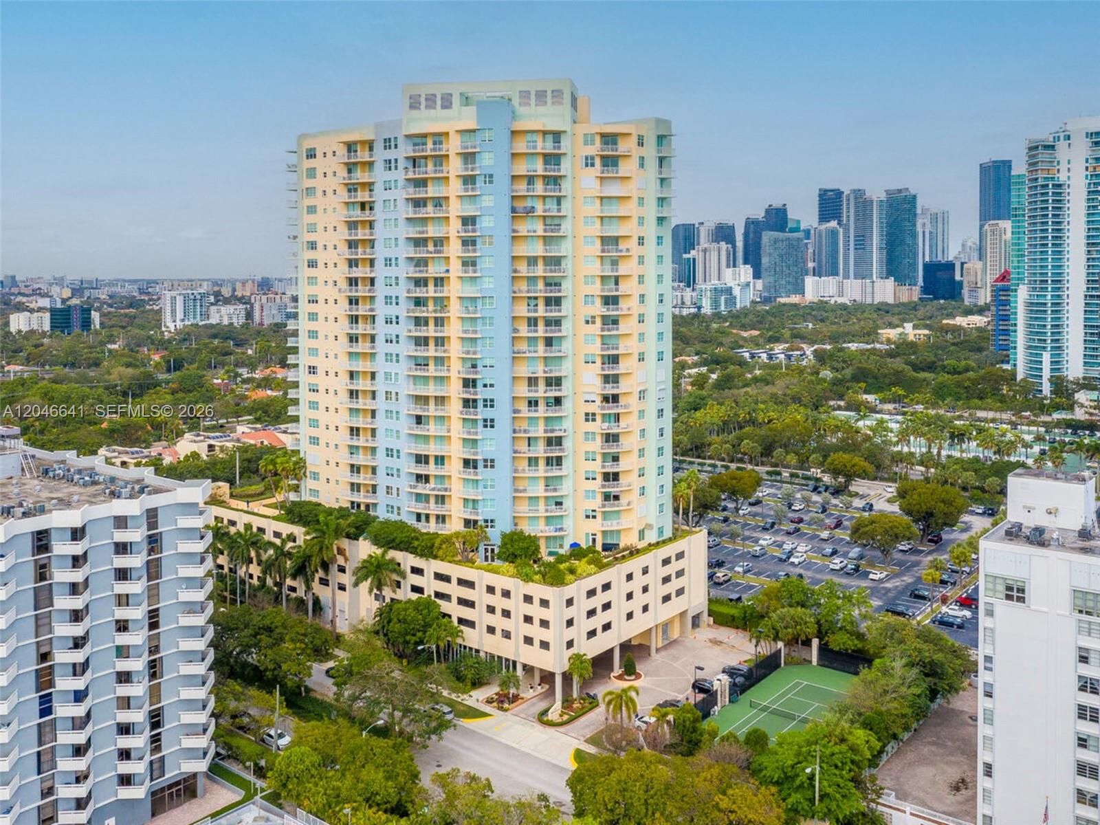 An aerial view shows a tall residential building with a parking garage and tennis court — 2475 Brickell Ave # 1805, Miami FL 33129, MIAMI, FL
