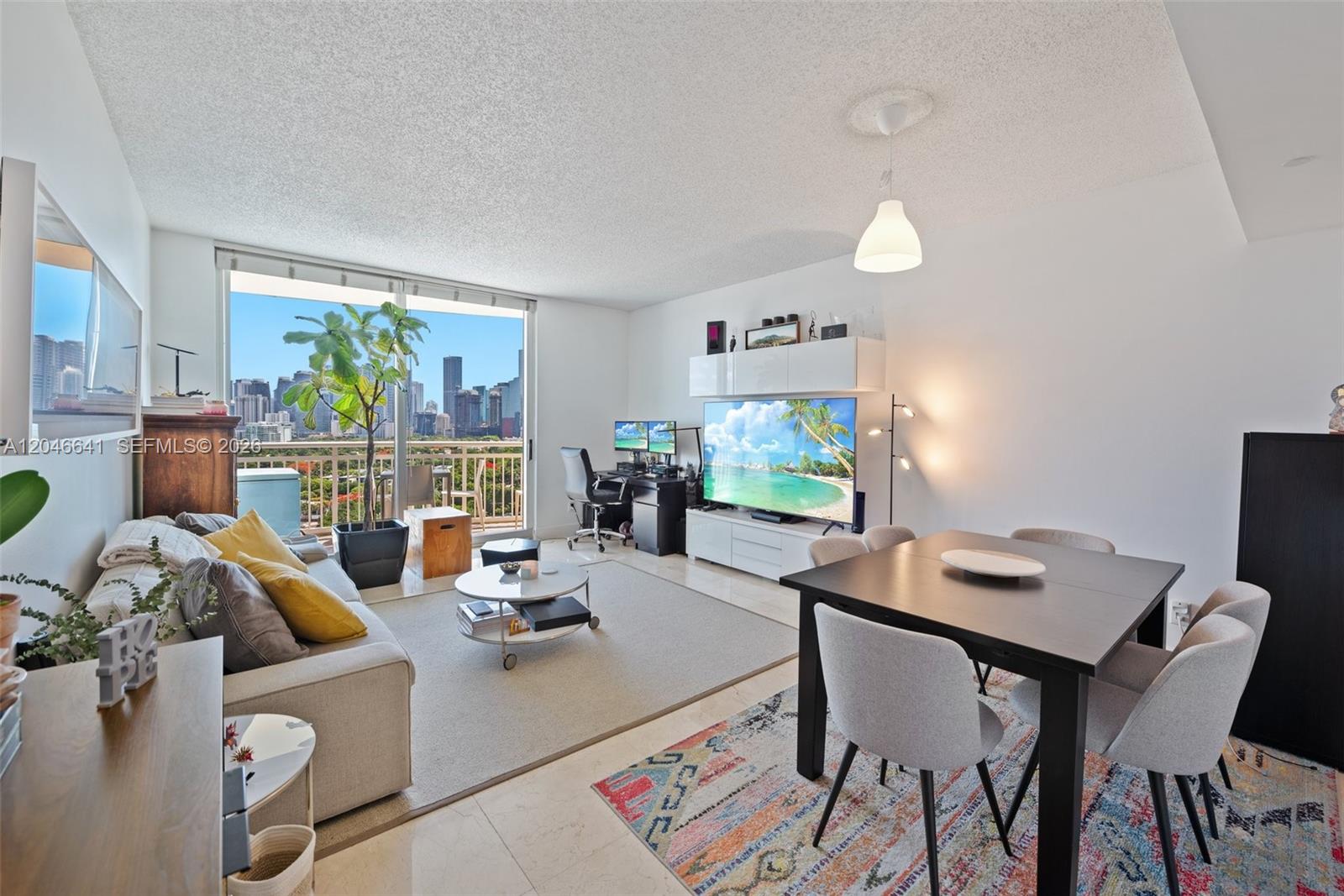 A living and dining area features a city view, modern furniture, and light tile floors — 2475 Brickell Ave # 1805, Miami FL 33129, MIAMI, FL