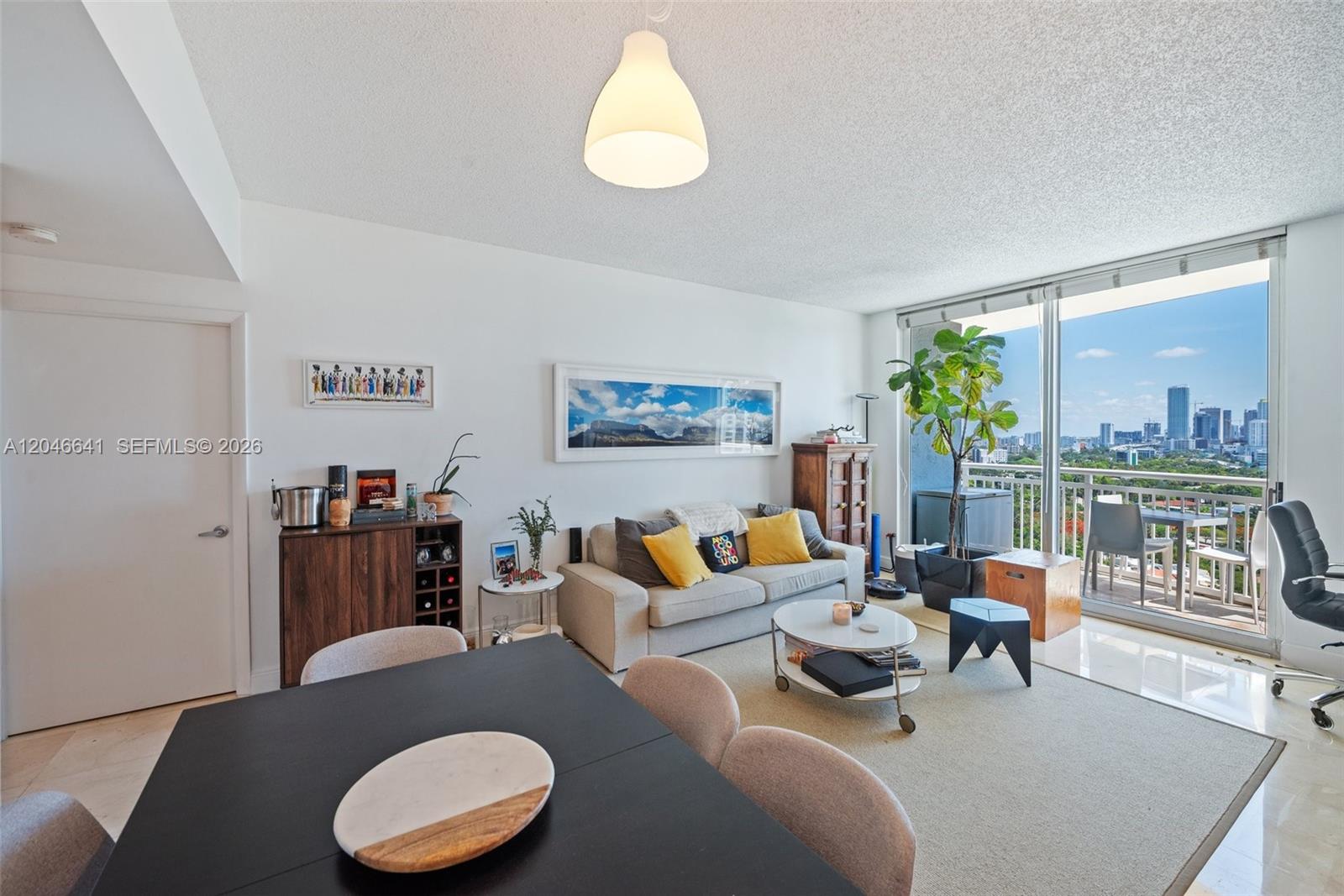 A living and dining area features a sofa, coffee table, and balcony with city views — 2475 Brickell Ave # 1805, Miami FL 33129, MIAMI, FL
