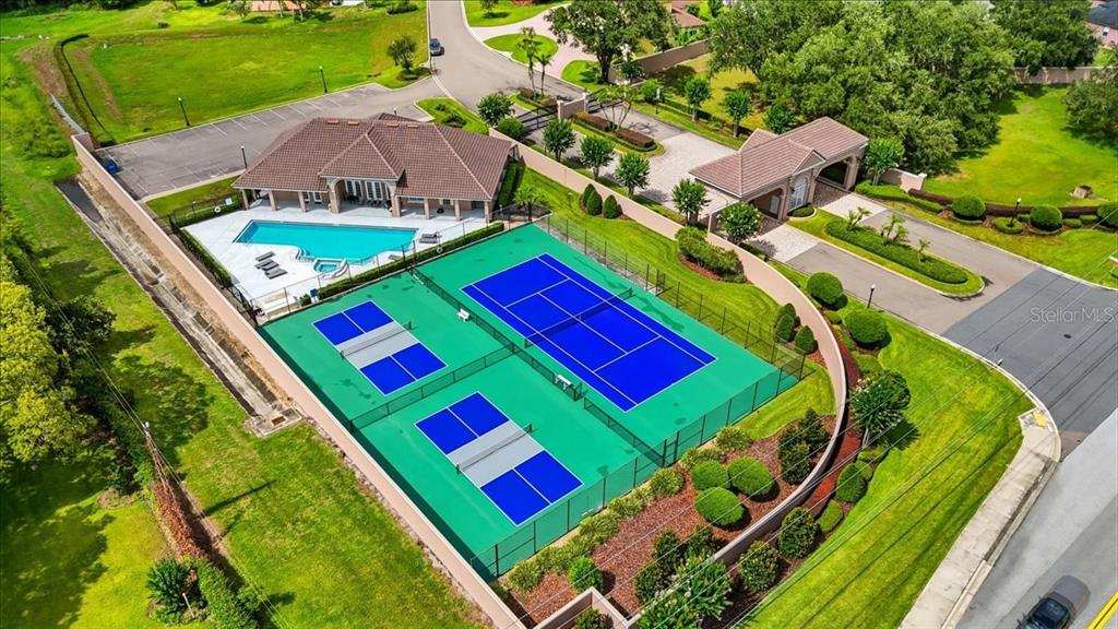 An aerial view shows a community clubhouse with a swimming pool and two tennis courts — 5112 HIGHLANDS LAKEVIEW LOOP, LAKELAND, FL